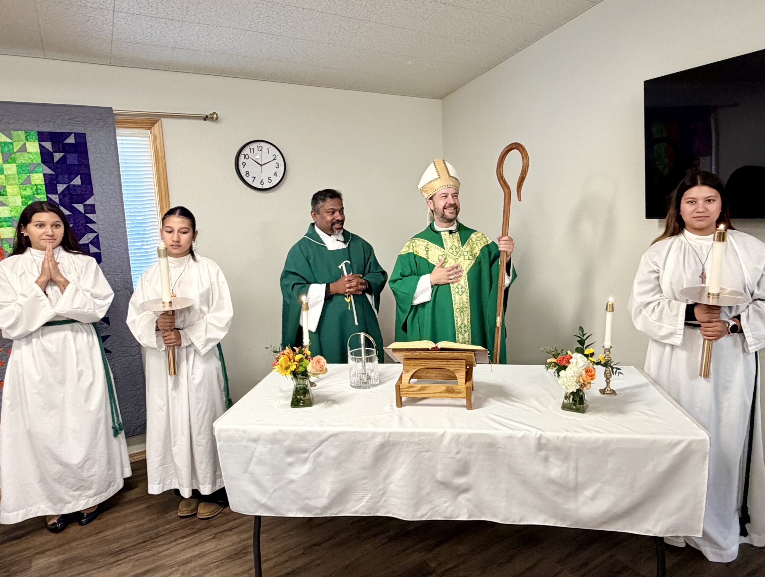 Fr Rijo and Bishop Hennen accompanied by altar servers dedicate teh newly renovated hall.